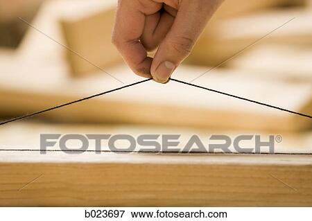 Stock Photo - hand holding a plumb line. Fotosearch