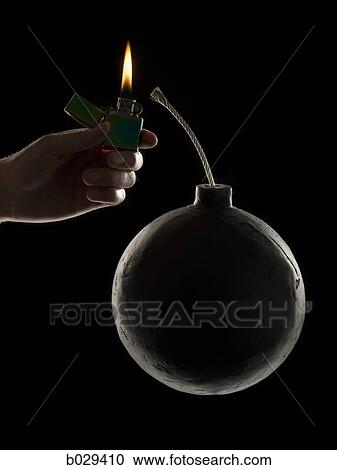 Stock Image - hand lighting the wick on a bomb. Fotosearch