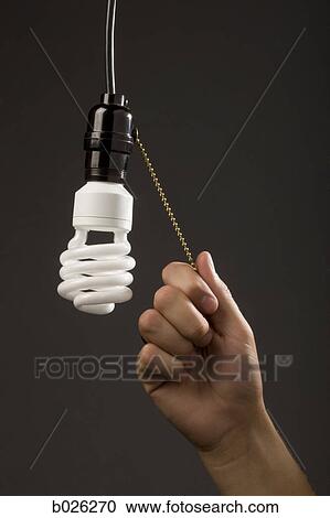 hand pulling chain on energy saving light bulb View Large Photo Image Stock Image - hand pulling chain on energy saving light bulb. Fotosearch