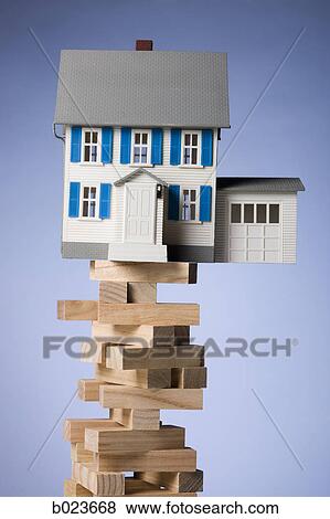 house perched precariously on a tower of blocks View Large Photo Image Stock Photo - house perched precariously on a tower of blocks. Fotosearch