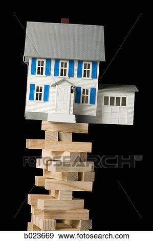 house perched precariously on a tower of blocks View Large Photo Image Stock Photo - house perched precariously on a tower of blocks. Fotosearch