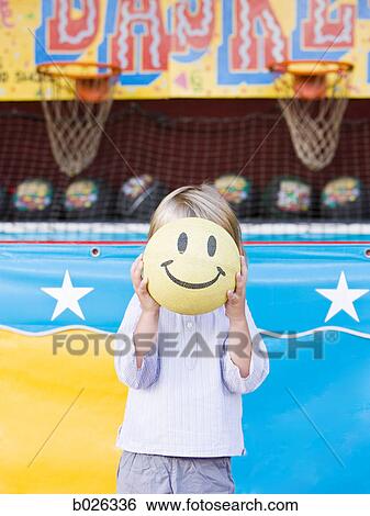 little boy holding up a smiley face at a carnival View Large Photo Image Stock Photograph - little boy holding up a smiley face at a carnival. Fotosearch