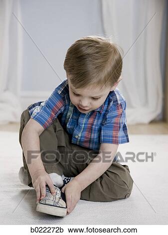 little boy putting on shoes View Large Photo Image Stock Image - little boy putting on shoes. Fotosearch