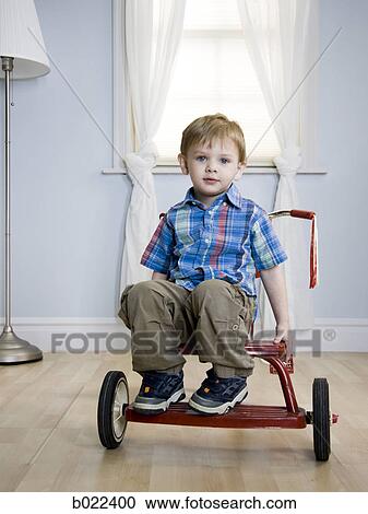 little boy riding a tricycle View Large Photo Image Stock Image - little boy riding a tricycle. Fotosearch