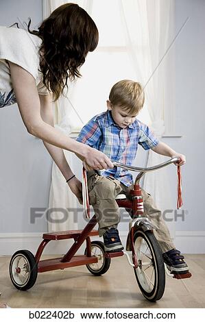 little boy riding a tricycle View Large Photo Image Stock Image - little boy riding a tricycle. Fotosearch