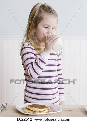Stock Image - little girl eating breakfast. Fotosearch