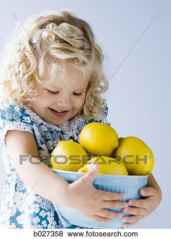 little girl holding a bowl of lemons View Large Photo Image Stock Photo - little girl holding a bowl of lemons. Fotosearch