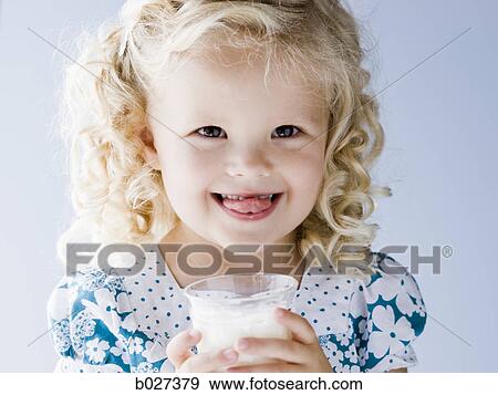 Stock Photo - little girl holding a glass of milk. Fotosearch
