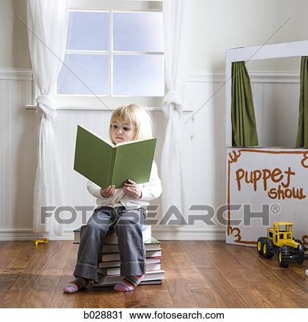 little girl reading a book while sitting on a stack of books View Large Photo Image Stock Image - little girl reading a book while sitting on a stack of books. Fotosearch