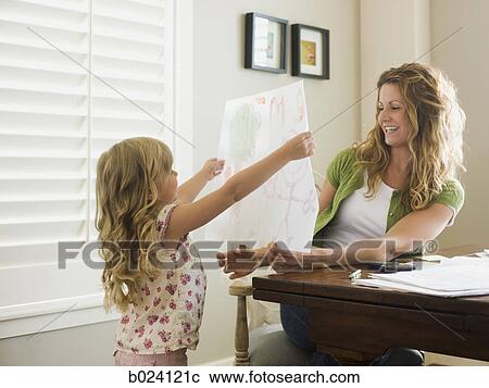 Stock Image - little girl showing her mother a drawing. Fotosearch