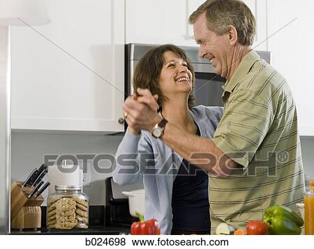 Stock Photo - man and woman dancing in a kitchen. Fotosearch