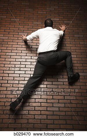 man climbing up a brick wall View Large Photo Image Stock Image - man climbing up a brick wall. Fotosearch