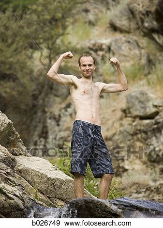 man flexing above a rock waterslide View Large Photo Image Stock Photo - man flexing above a rock waterslide. Fotosearch