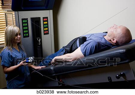 Stock Photo - man getting treatment on a chiropractic machine. Fotosearch
