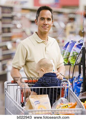 Stock Image - man grocery shopping with baby. Fotosearch