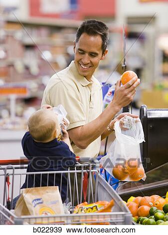 Stock Photo - man grocery shopping with baby. Fotosearch
