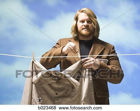 man hanging shirt on a clothesline View Large Photo Image Stock Photo - man hanging shirt on a clothesline. Fotosearch
