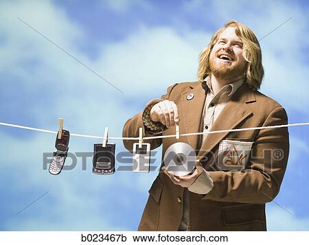 man hanging tech devices on a clothesline View Large Photo Image Stock Image - man hanging tech devices on a clothesline. Fotosearch