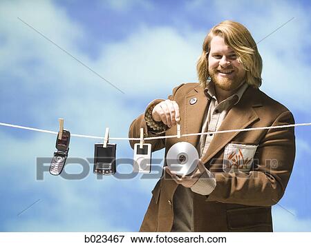 man hanging tech devices on a clothesline View Large Photo Image Stock Photo - man hanging tech devices on a clothesline. Fotosearch