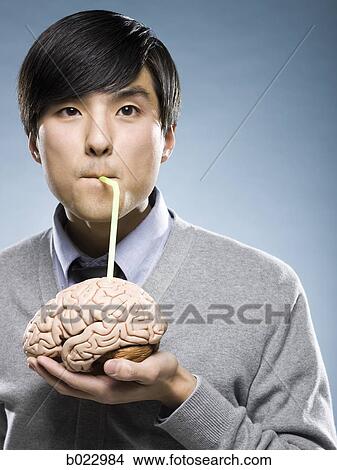 man holding a brain with a drinking straw sticking out of it View Large Photo Image Picture - man holding a brain with a drinking straw sticking out of it. Fotosearch