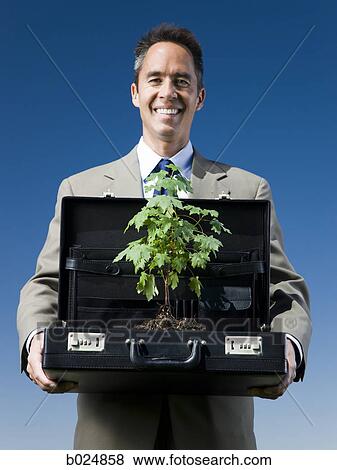 man holding a briefcase with a tree in it View Large Photo Image Stock Photo - man holding a briefcase with a tree in it. Fotosearch