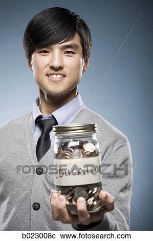 man holding a jar of coins View Large Photo Image Stock Image - man holding a jar of coins. Fotosearch