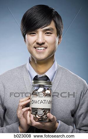 man holding a jar of coins View Large Photo Image Stock Photo - man holding a jar of coins. Fotosearch