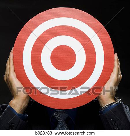 man holding a red target in front of his face View Large Photo Image Stock Image - man holding a red target in front of his face. Fotosearch
