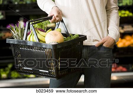 man holding a shopping basket View Large Photo Image Stock Photo - man holding a shopping basket. Fotosearch
