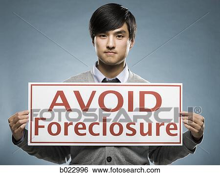 man holding an "avoid foreclosure" sign View Large Photo Image Stock Photograph - man holding an "avoid foreclosure" sign. Fotosearch