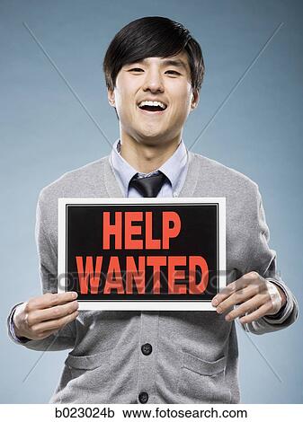Stock Image - man holding help wanted sign. Fotosearch