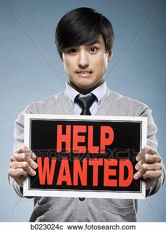 Stock Image - man holding help wanted sign. Fotosearch