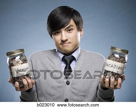 Stock Image - man holding two jars of coins. Fotosearch