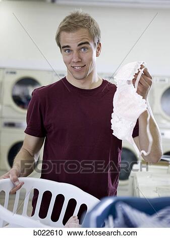 Stock Image - man holding up a bra. Fotosearch