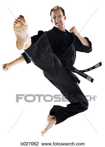 Stock Image - man in a black karate gi practicing martial arts. Fotosearch