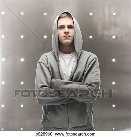 man in a hoodie with his arms crossed View Large Photo Image Stock Image - man in a hoodie with his arms crossed. Fotosearch