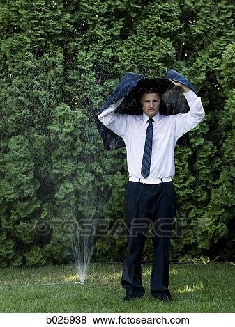man in a suit standing next to a sprinkler View Large Photo Image Stock Photo - man in a suit standing next to a sprinkler. Fotosearch