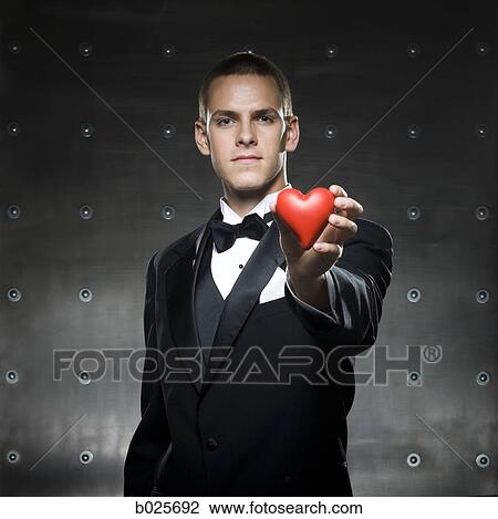 man in a tuxedo holding a heart View Large Photo Image Stock Image - man in a tuxedo holding a heart. Fotosearch