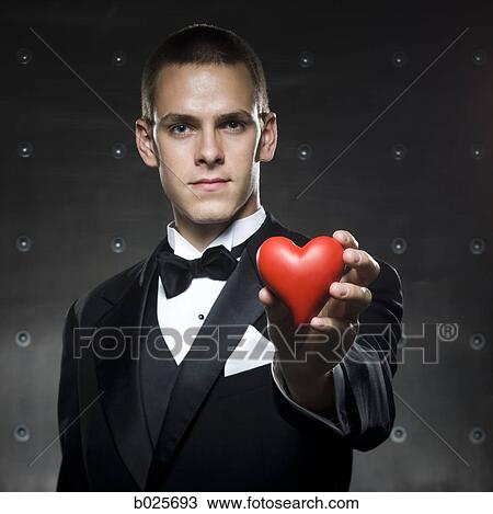 man in a tuxedo holding a heart View Large Photo Image Stock Image - man in a tuxedo holding a heart. Fotosearch