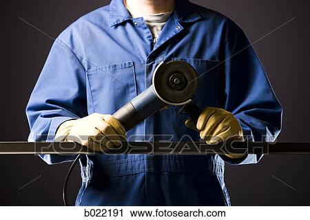 man in blue coveralls with a power grinder View Large Photo Image Stock Image - man in blue coveralls with a power grinder. Fotosearch