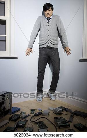 Picture - man in the corner surrounded by computer parts. Fotosearch