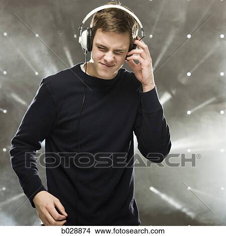 Picture - man listening to music through headphones. Fotosearch