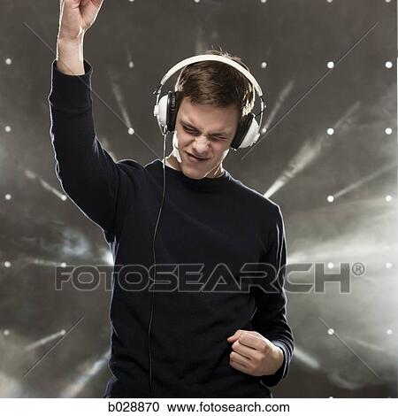 Stock Image - man listening to music through headphones. Fotosearch