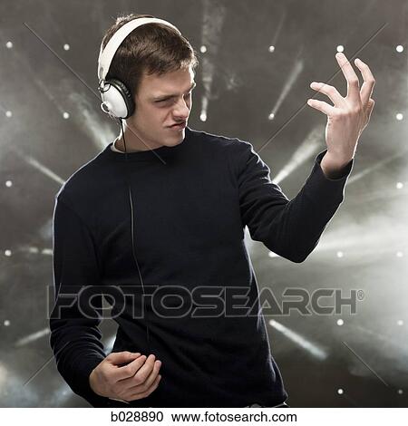 Stock Image - man listening to music through headphones. Fotosearch