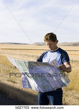 man looking at a map on the side of the road View Large Photo Image Stock Image - man looking at a map on the side of the road. Fotosearch