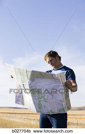 man looking at a map on the side of the road View Large Photo Image Stock Image - man looking at a map on the side of the road. Fotosearch