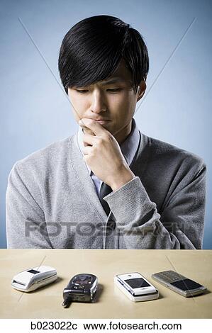 man looking at cell phones View Large Photo Image Stock Image - man looking at cell phones. Fotosearch