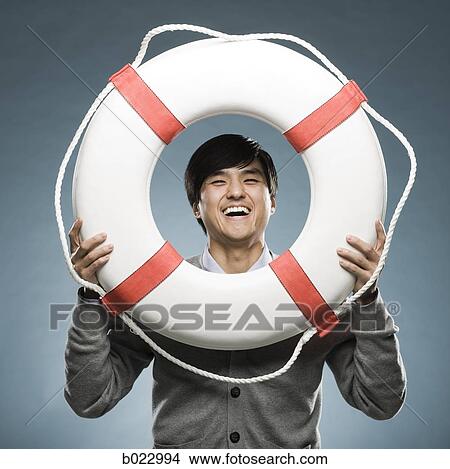 man looking through the hole of a life preserver View Large Photo Image Picture - man looking through the hole of a life preserver. Fotosearch
