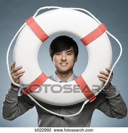 man looking through the hole of a life preserver View Large Photo Image Stock Image - man looking through the hole of a life preserver. Fotosearch