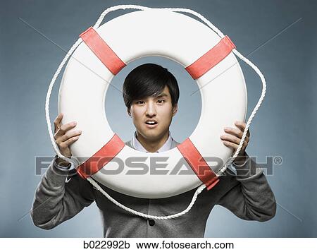man looking through the hole of a life preserver View Large Photo Image Stock Image - man looking through the hole of a life preserver. Fotosearch